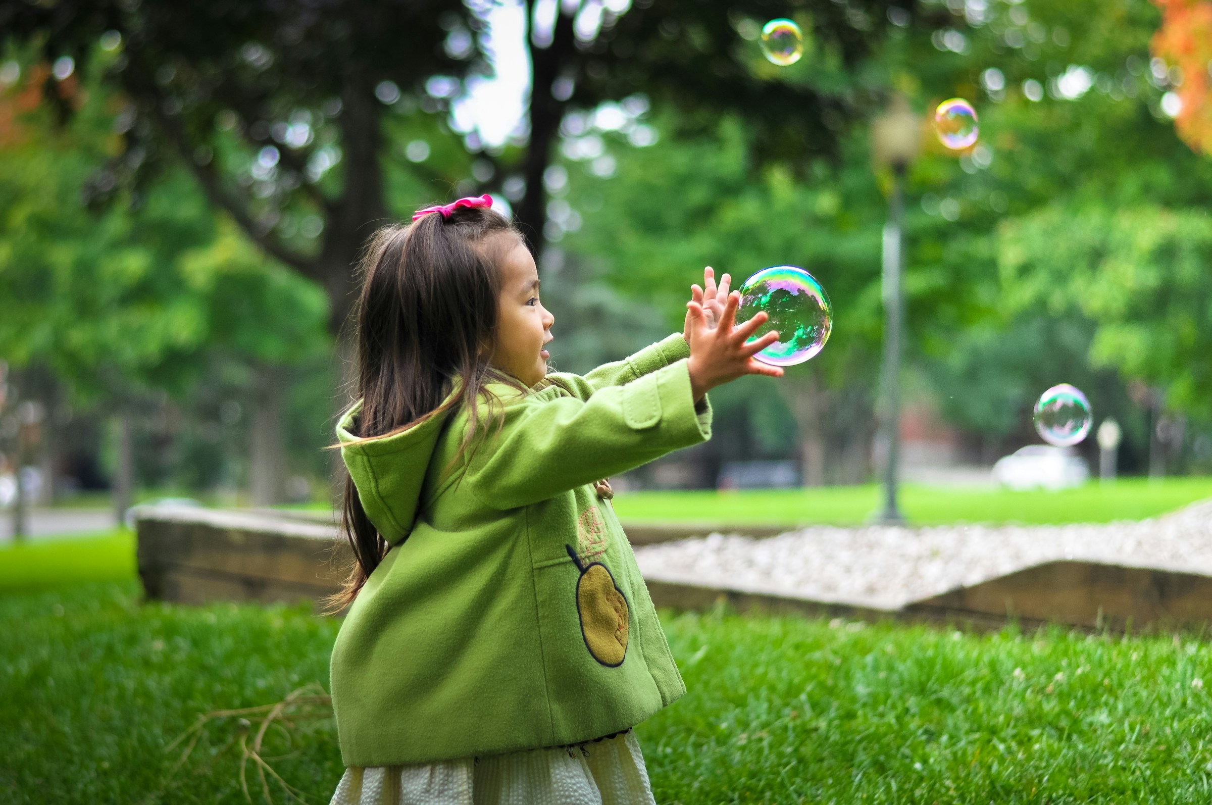 child in green jacket at the park